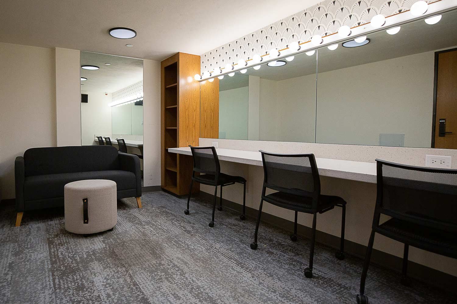 Dressing room with well lit seating area and mirrors