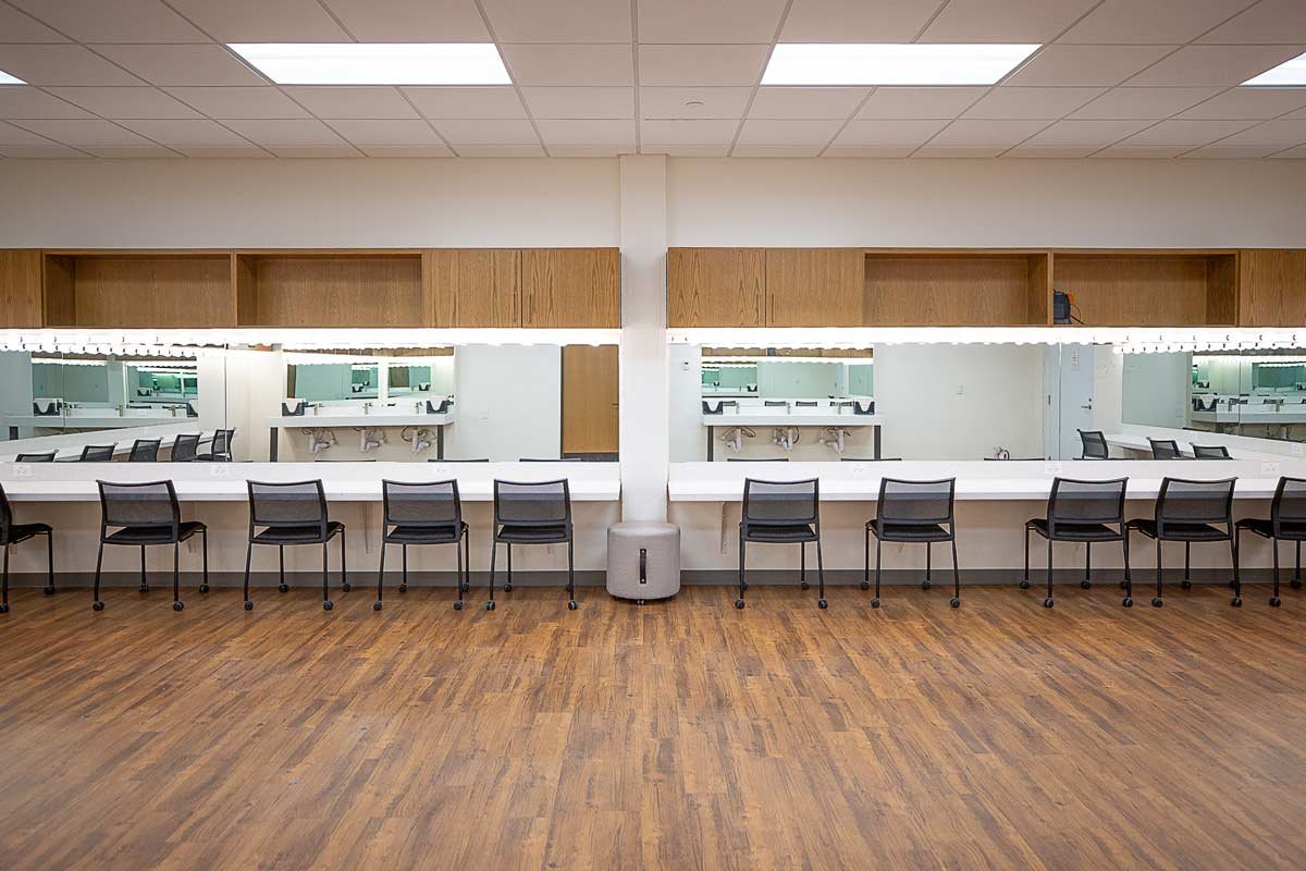 Dressing area with mirrored wall and multiple chairs