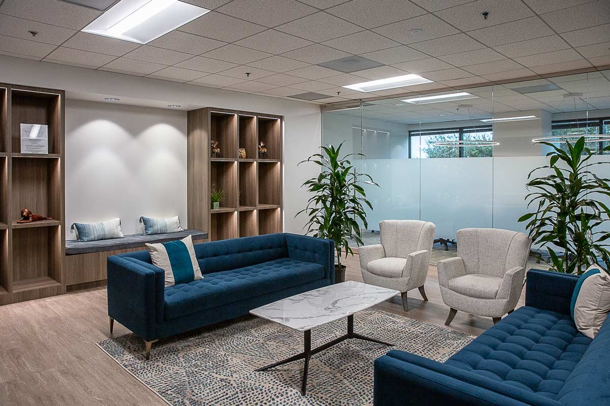 Seating area with blue couches and white chairs