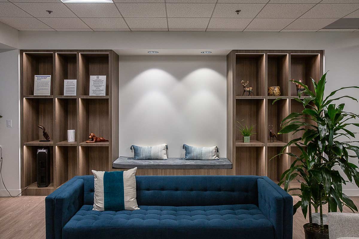 Seating are with blue couch, plants and wall shelves