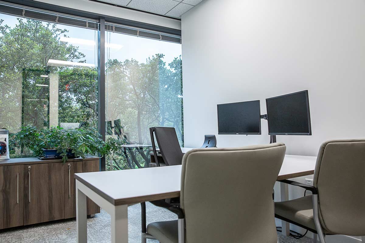 New office with desk and monitors looking out at the trees