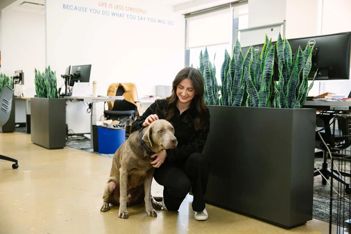 Woman knelling with dog in office