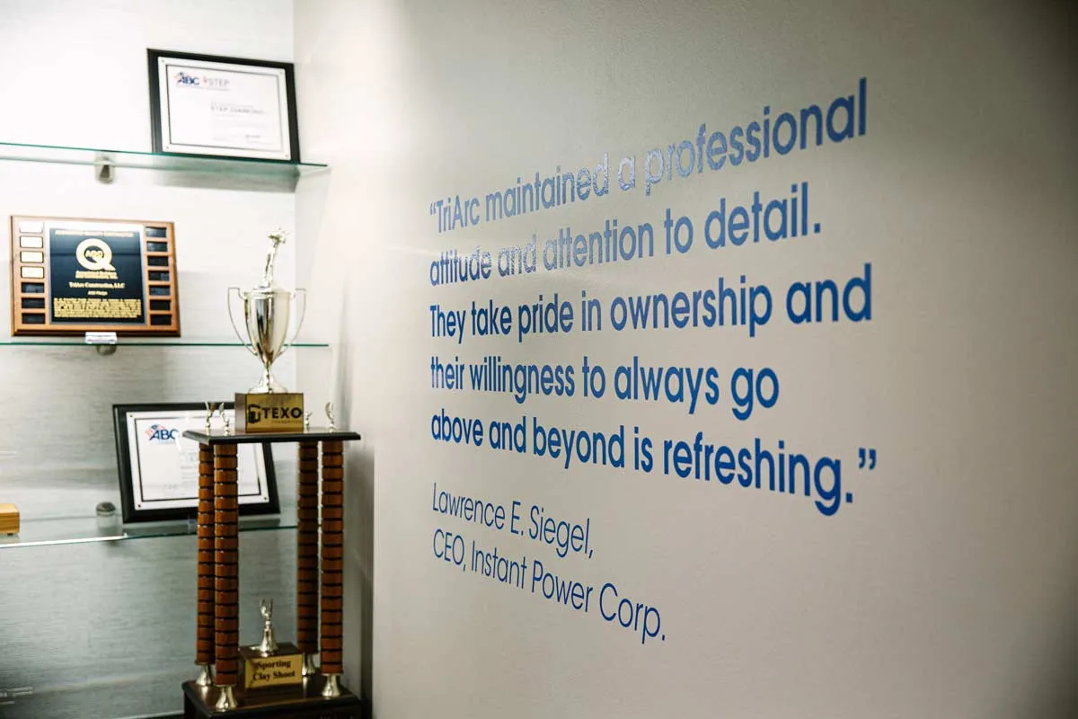 Culture quote stenciled on wall with awards and trophies
