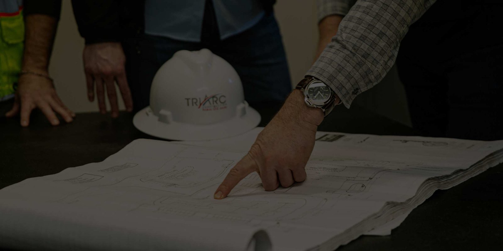 Man pointing to blueprints on table